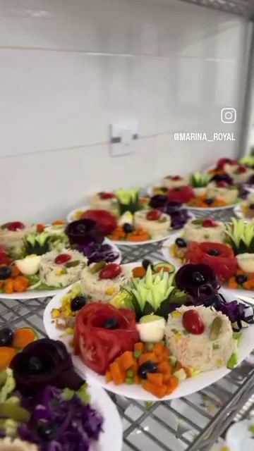 Buffet d'entrées froides : une dizaine d'assiettes composées et sculptées, alignées avant le service
