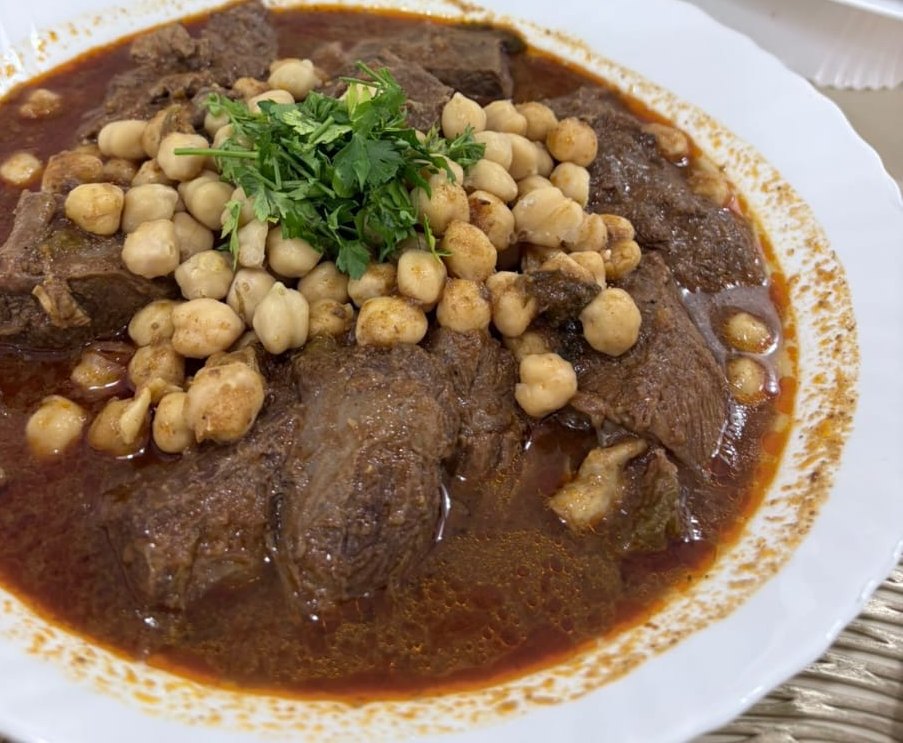 Plat mijoté de viande aux pois chiches, garni de coriandre fraîche