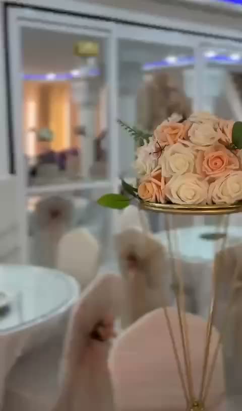 Composition de roses pêche posée sur une table dressée